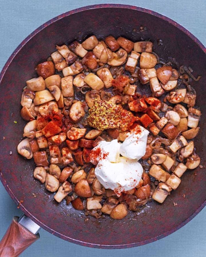 Cream and mustard added to the pan. Paprika is sprinkled over everything.