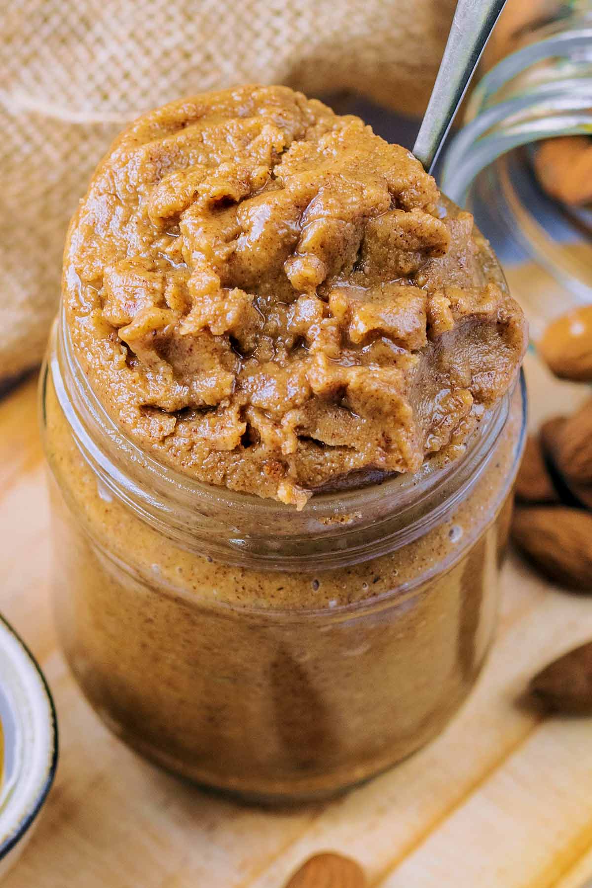 A jar of almond butter with a spoon in it.