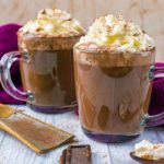 Cinnamon Mocha in two glass mugs topped with cream.