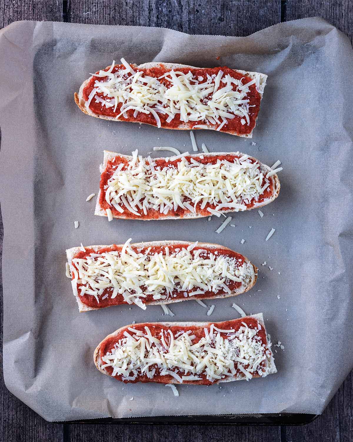 Grated cheddar cheese on top of the pizza sauce.
