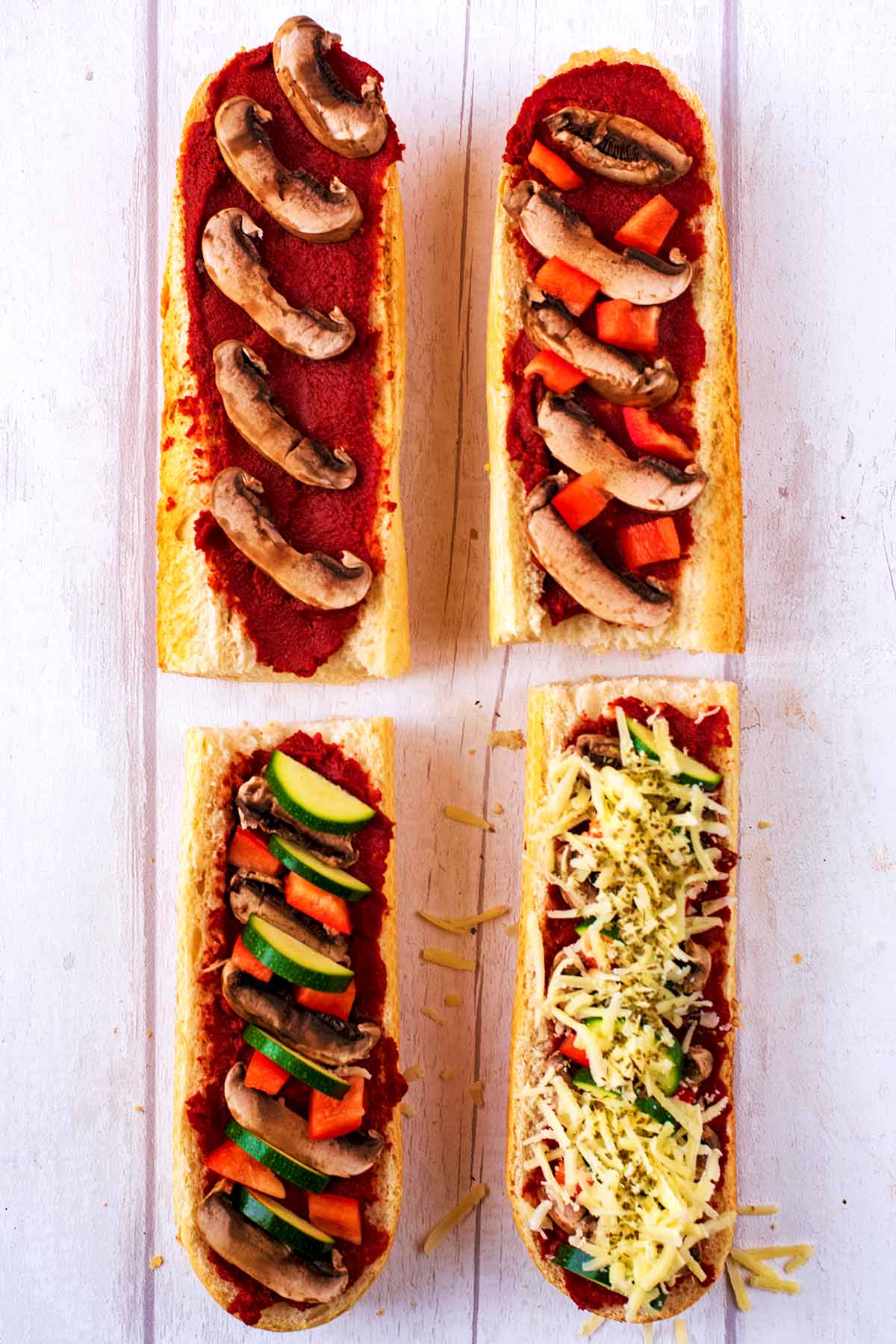 Sliced vegetables added to all of the french bread pieces with cheese added to one of them too.