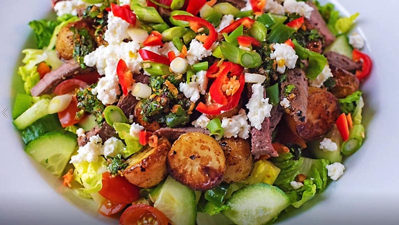 Steak salad topped with red chillies and feta.