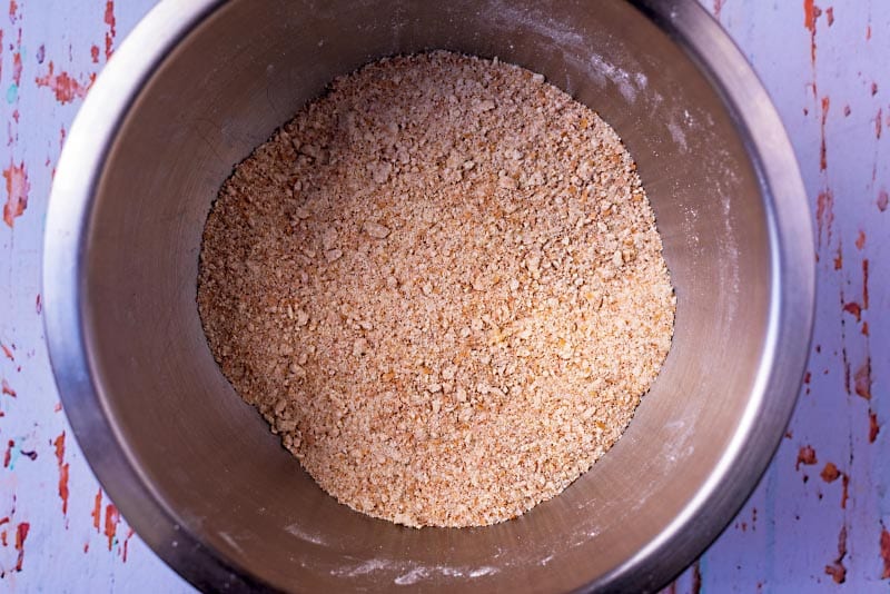 A mixing bowl with flour and butter mixed to a breadcrumb like consistency.