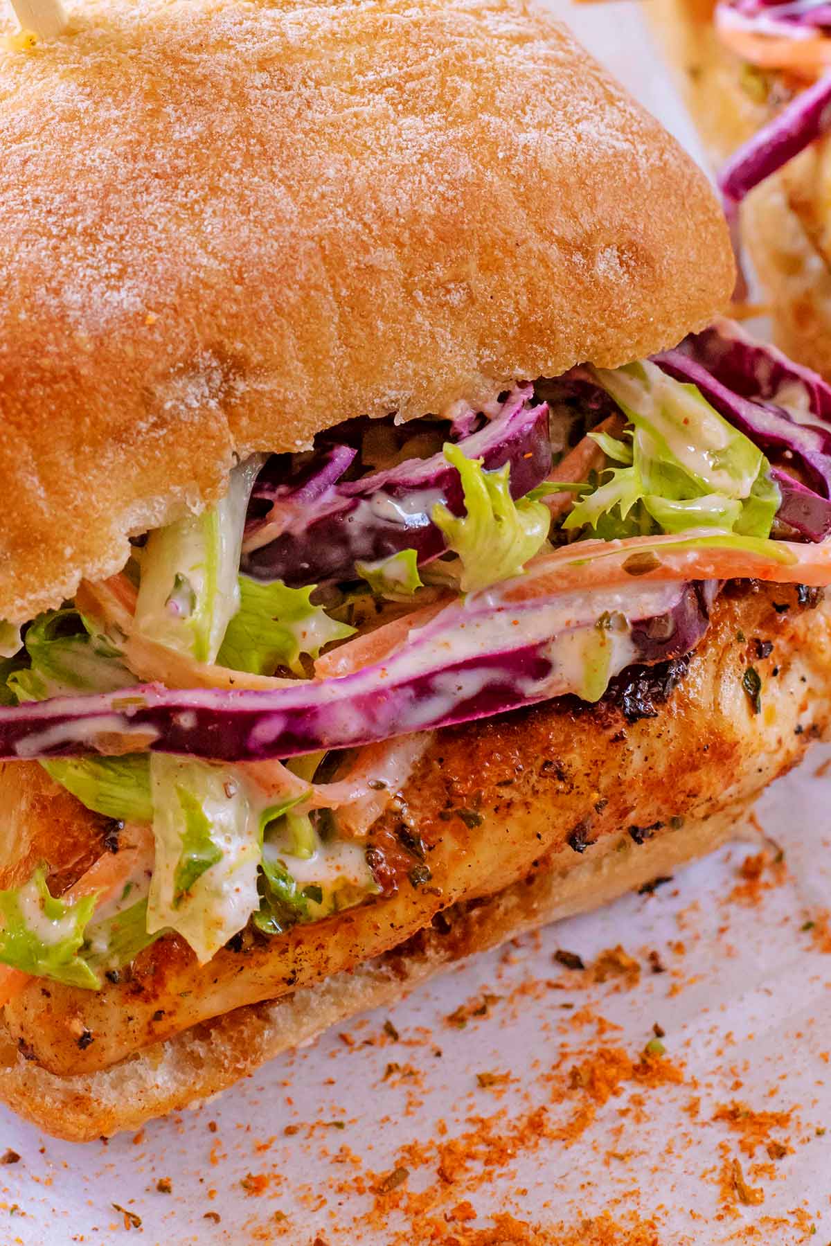 A ciabatta roll with cajun spiced chicken and slaw in it.