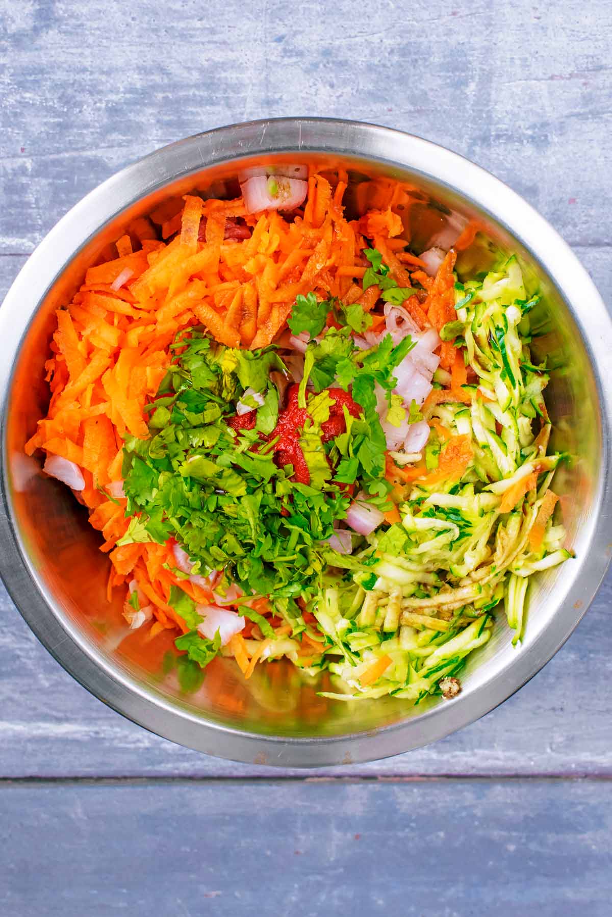 Crushed garlic, egg, tomato puree and chopped herbs added to the bowl.