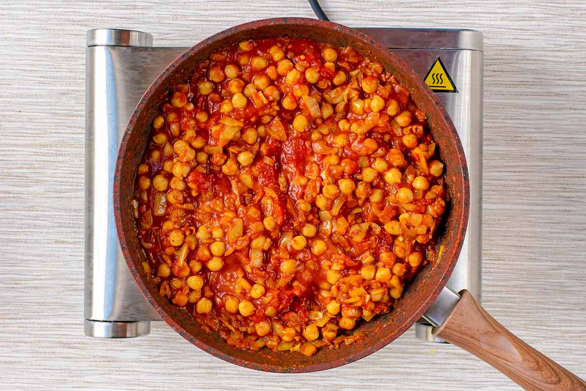 Chopped tomatoes and chickpeas added to the pan and mixed in.