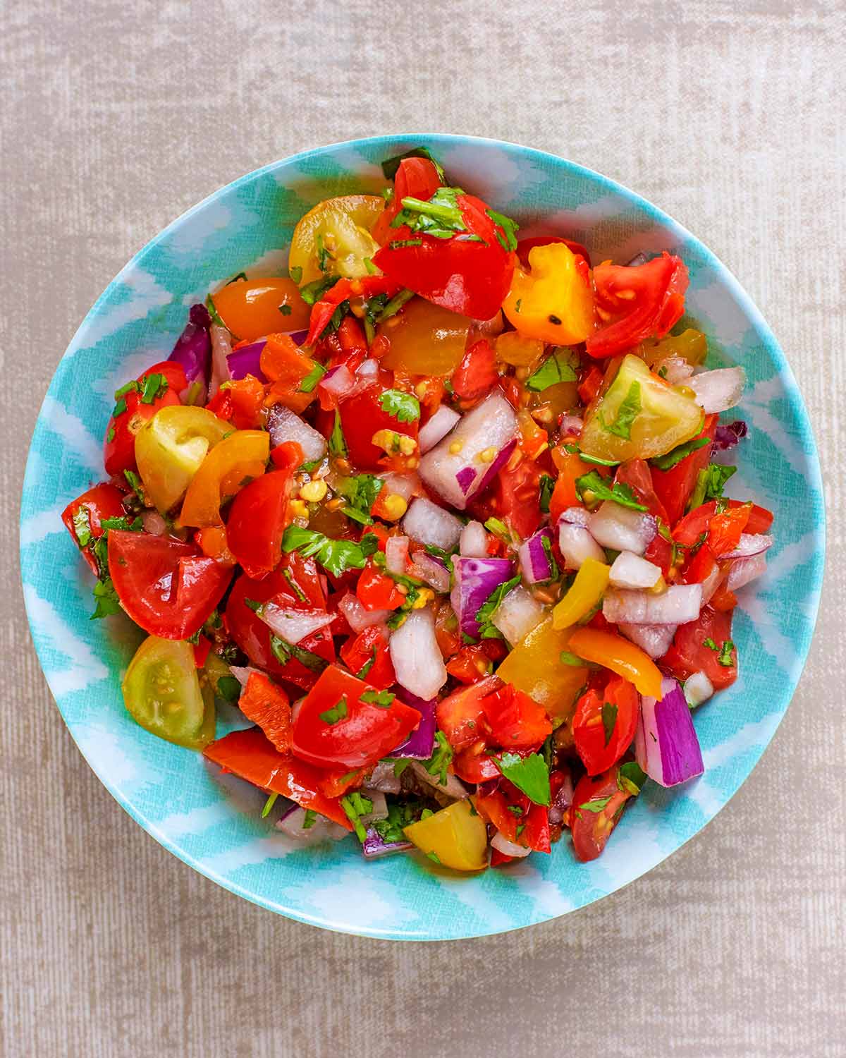 A small blue bowl containing tomato salsa.