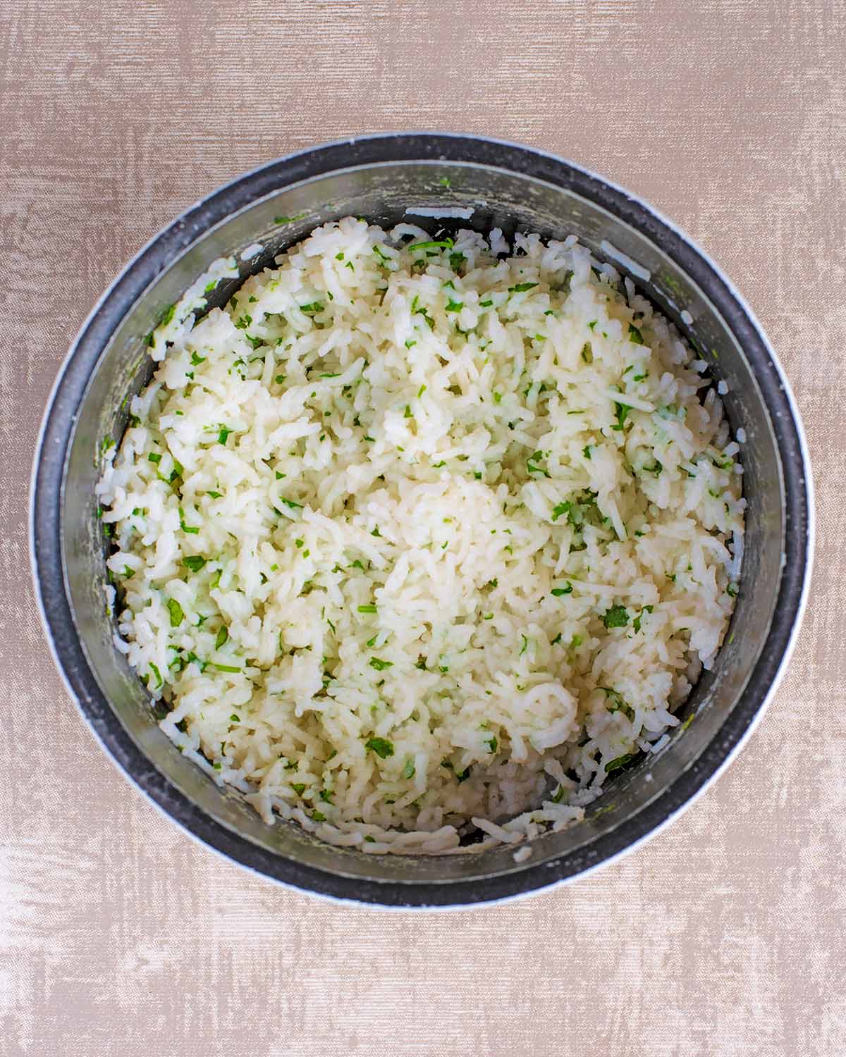 A black saucepan containing cooked white rice.
