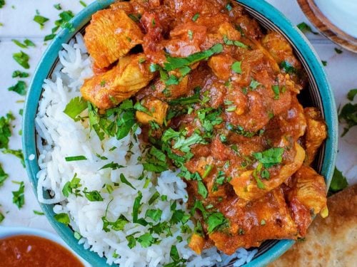 Tomato and Garlic chicken curry in a blue bowl.