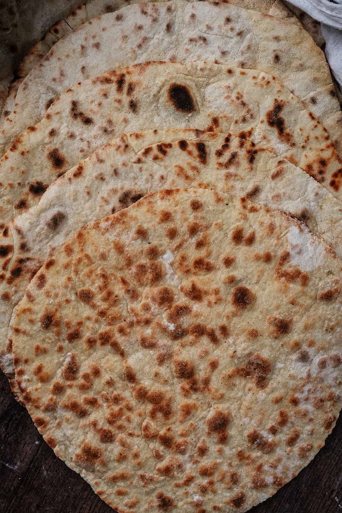 Flatbreads fanned out on a wooden surface.