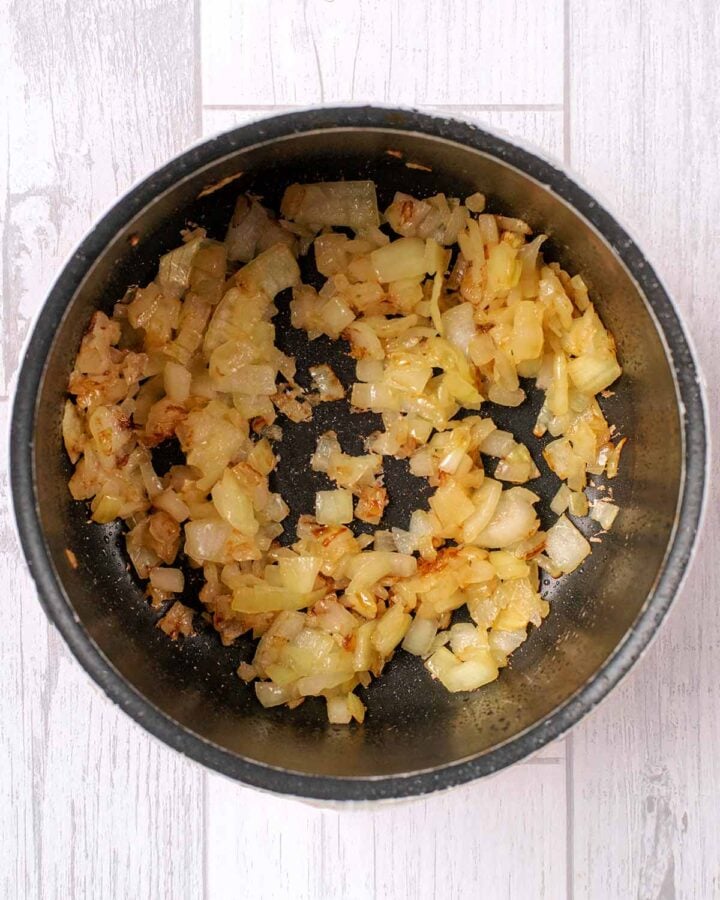Chopped onions cooking in a saucepan.