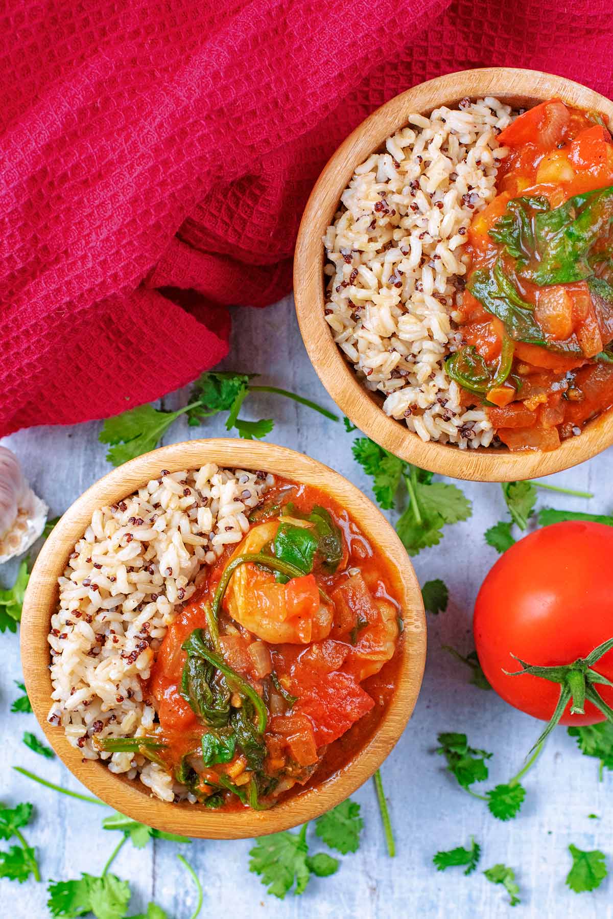 Two bowls of curry and rice next to a red towel.