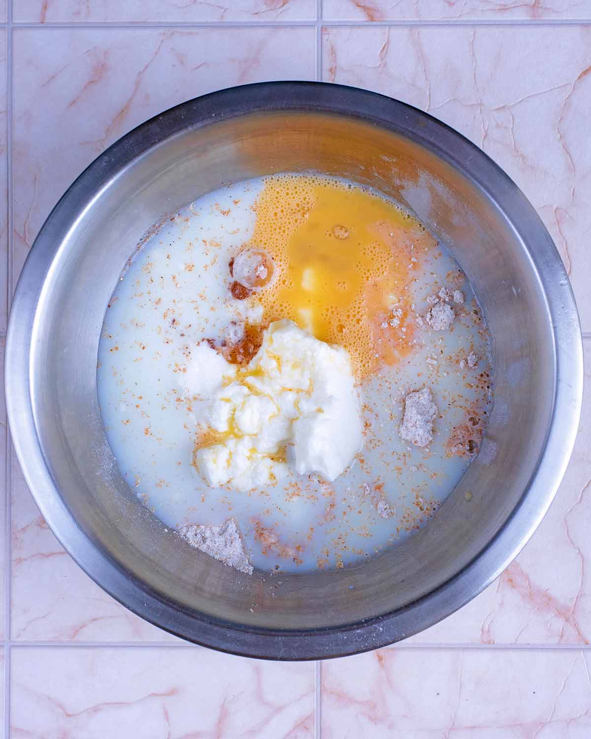 Milk, egg, yogurt and vanilla in a mixing bowl.