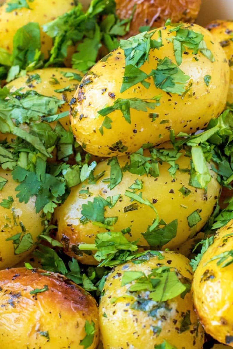 Cooked potatoes covered in chopped herbs.