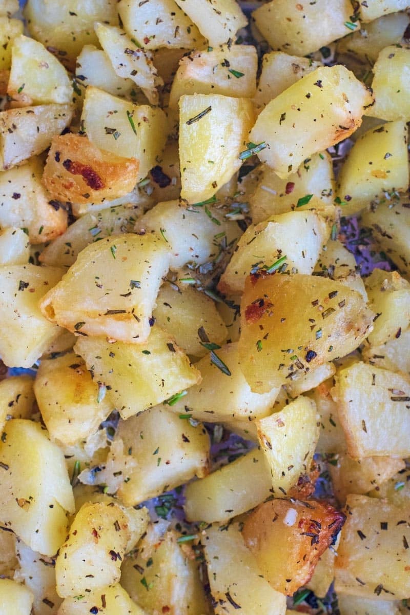 Roasted potato chunks covered in herbs and spices.