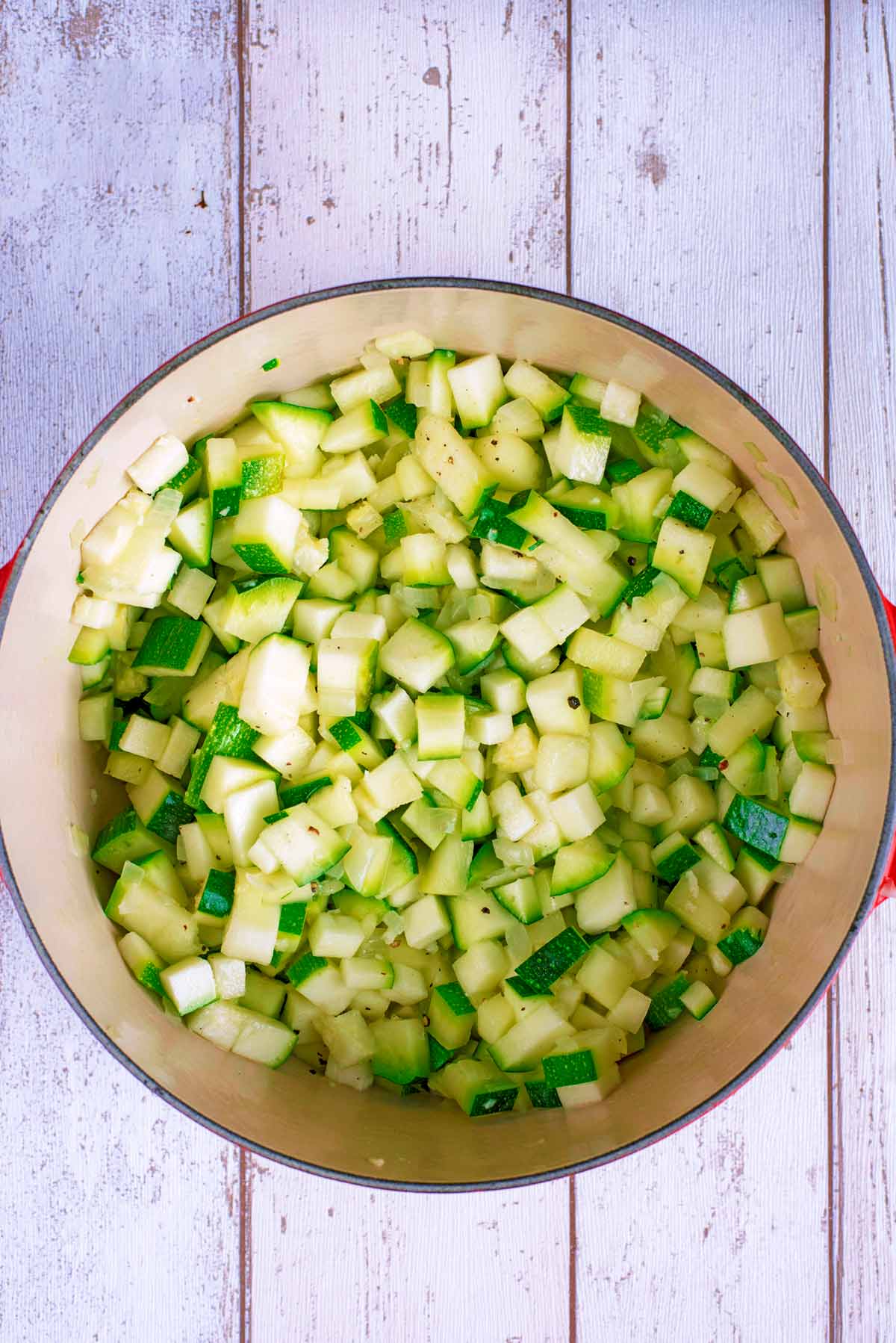 Chopped courgette and onions in a large pan.