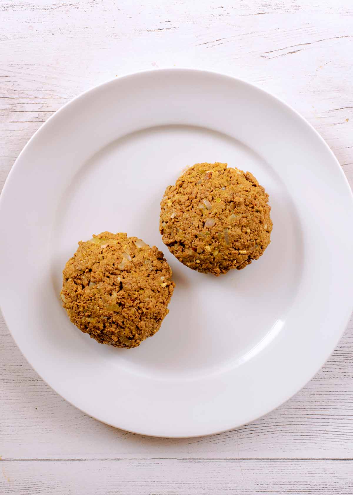 Two meat free quorn burgers on a white plate.