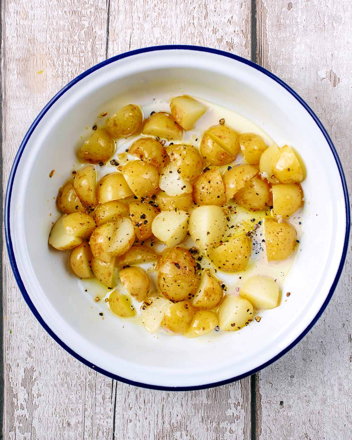 Chopped new potatoes, oil and seasoning in a round baking dish.