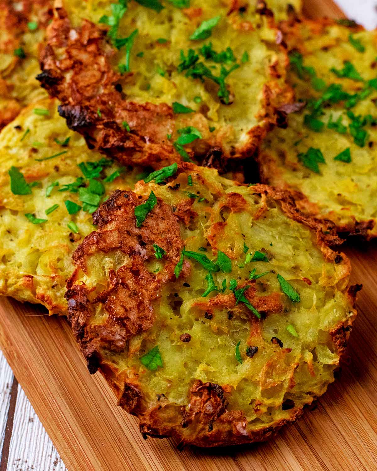 A pile of baked hash browns on a wooden board.