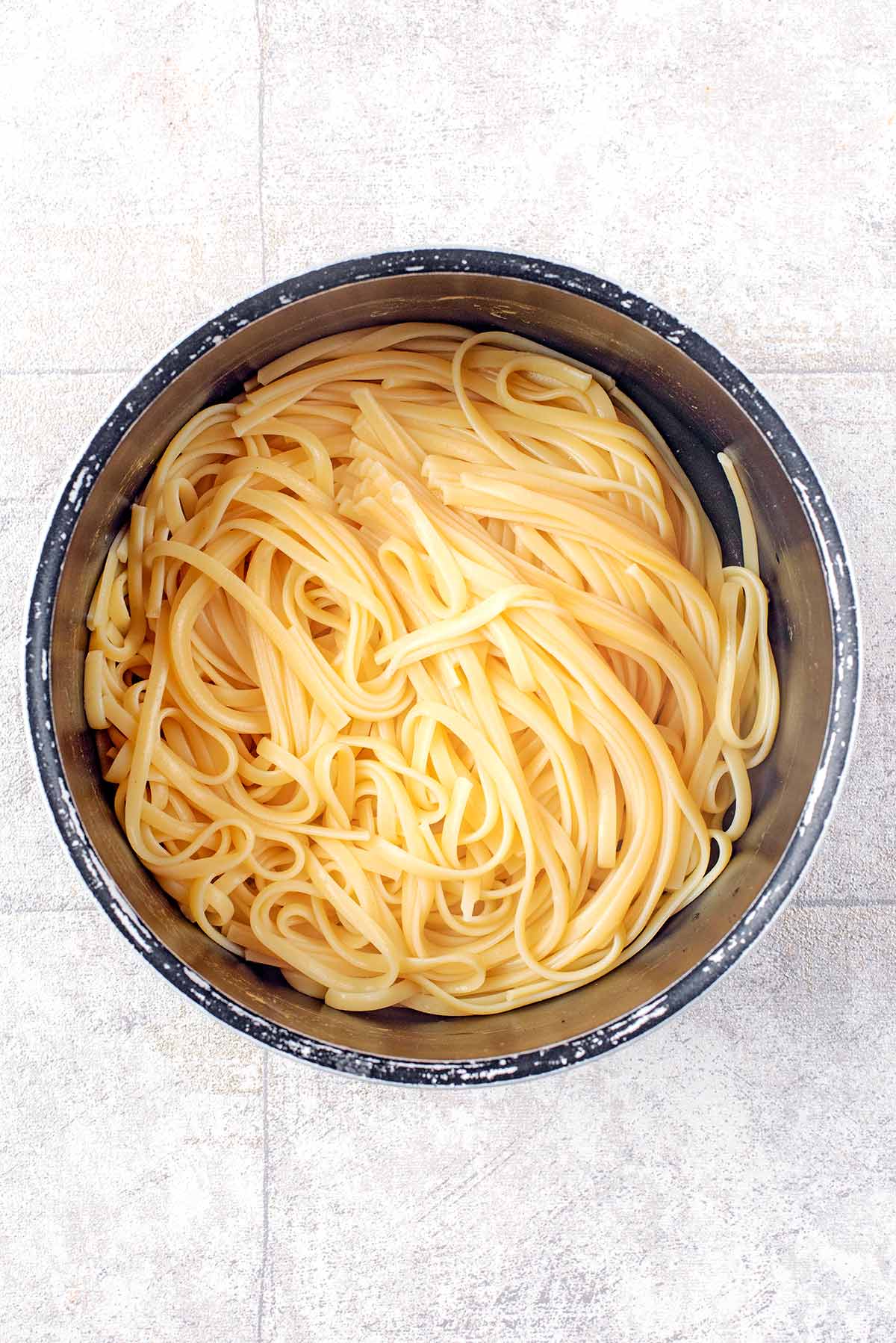 A saucepan full of cooked linguine.