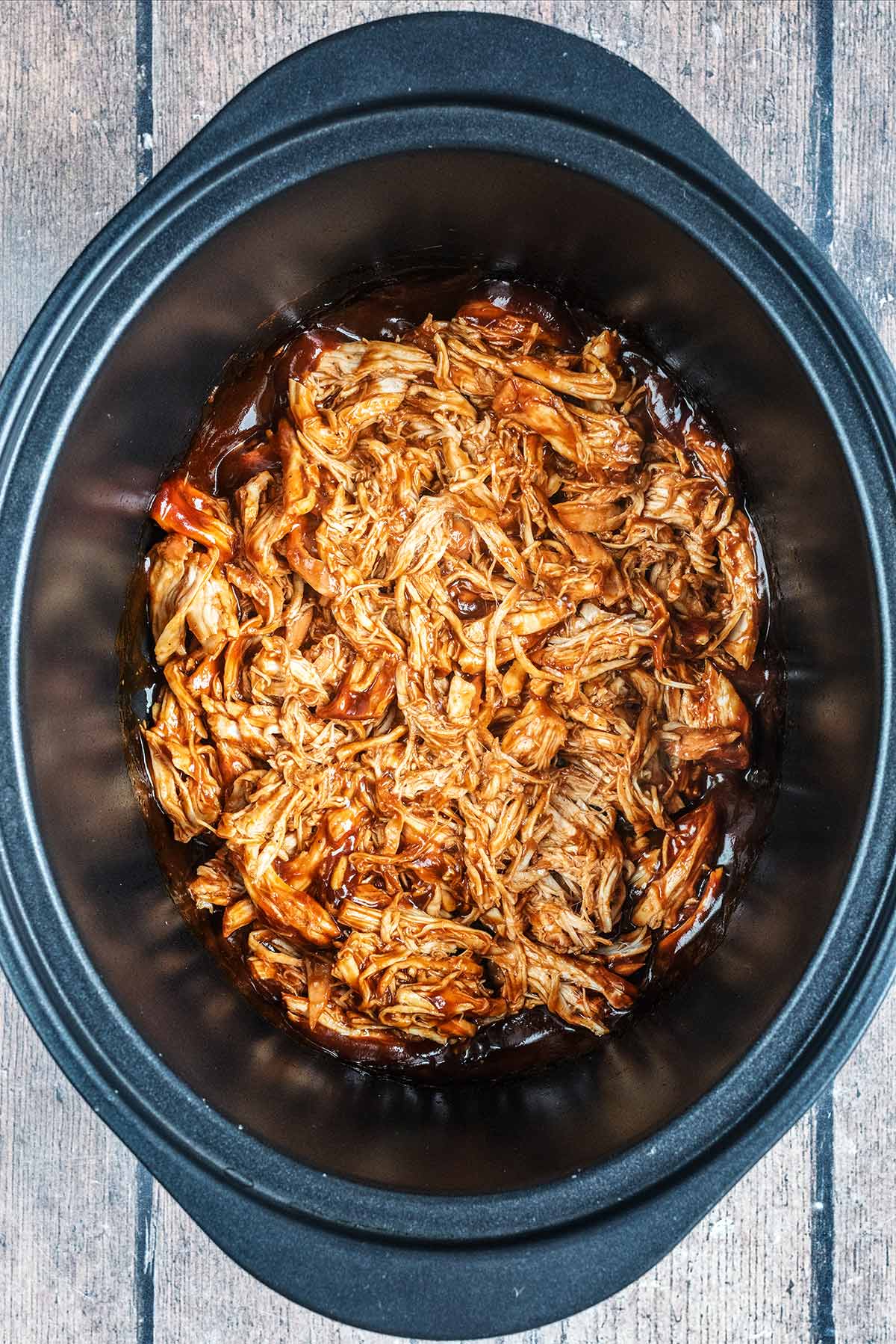 BBQ pulled chicken in a slow cooker pot.