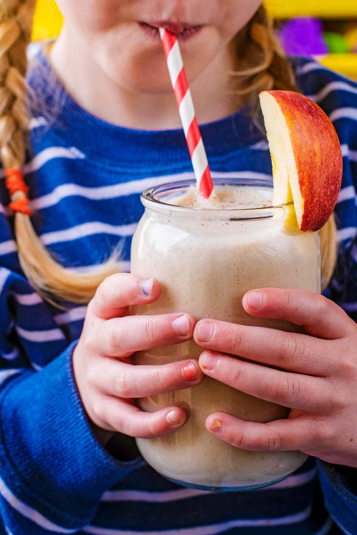 A child drinking a smoothie through a straw.