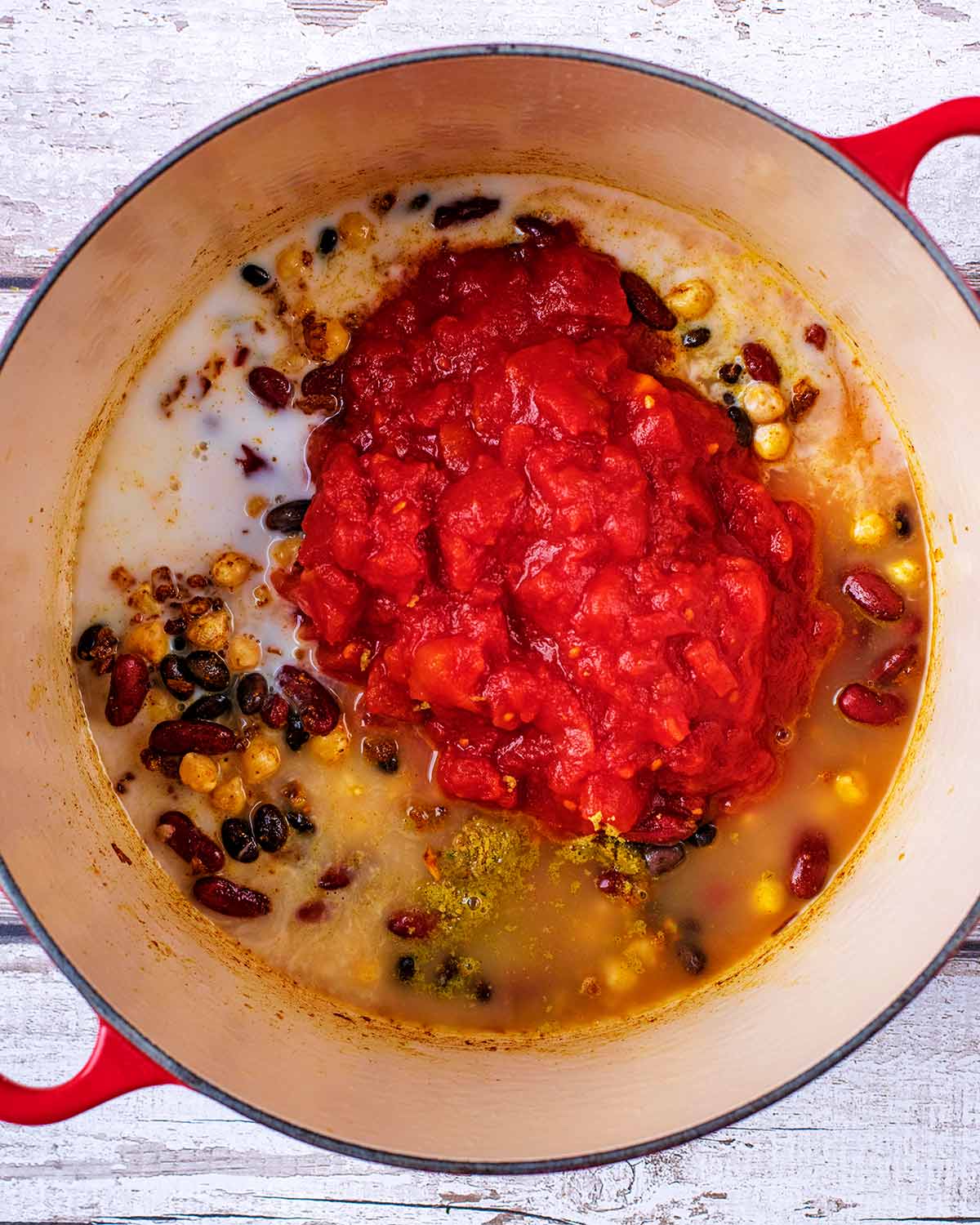 Chopped tomatoes, coconut milk and stock added to the pan.
