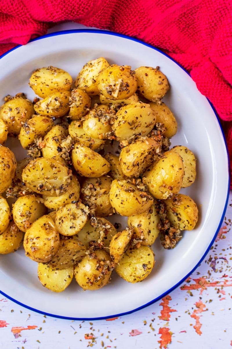 Roasted Potatoes in a bowl on a wooden surface.