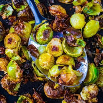 Roasted Brussels sprouts on a large serving spoon.
