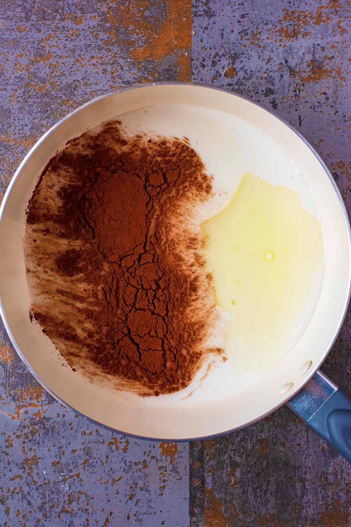 A saucepan with milk, cocoa powder and vanilla.