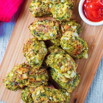 Cheesy Baked Broccoli Bites on a wooden board with a pot of ketchup