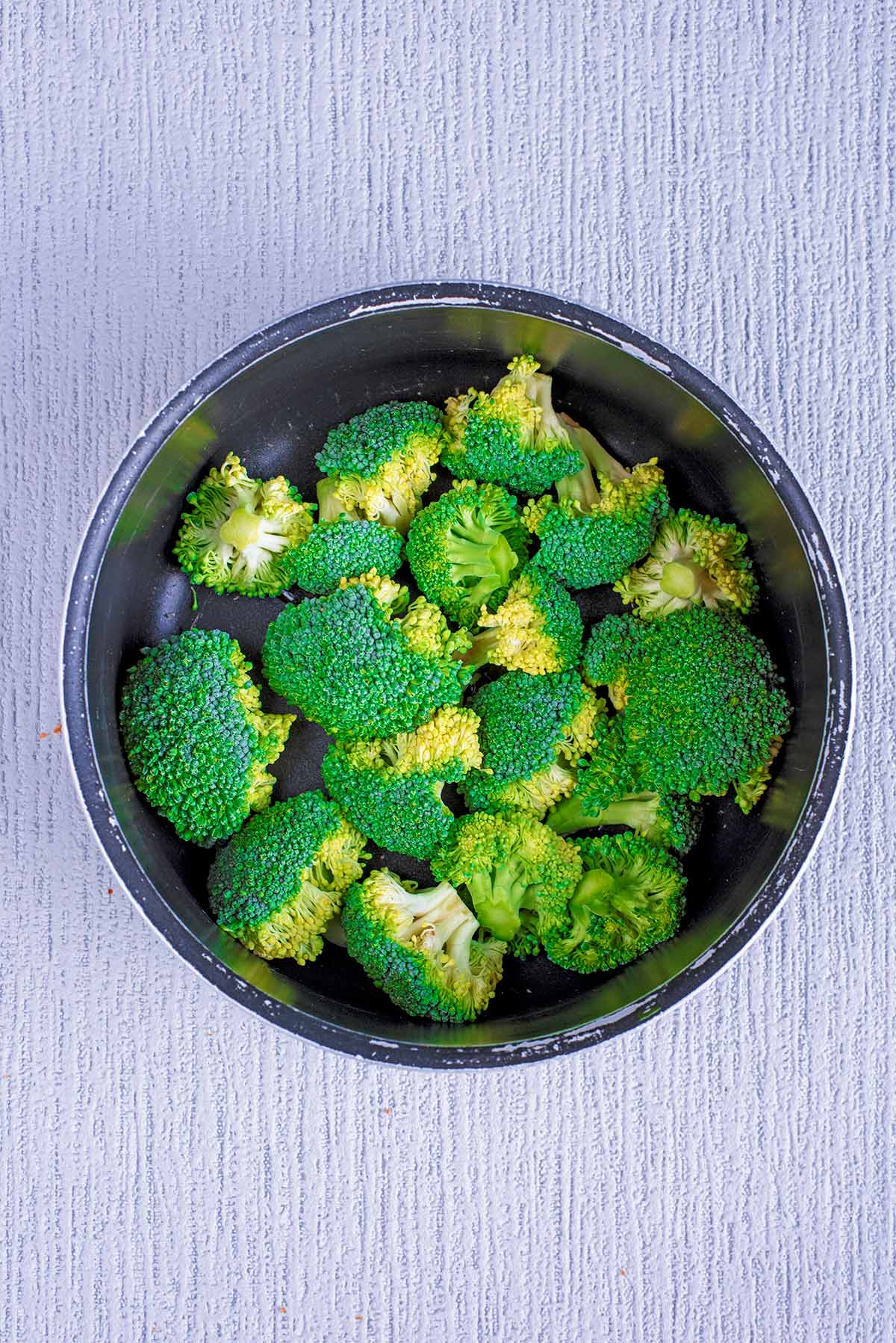 Broccoli florets in a saucepan.