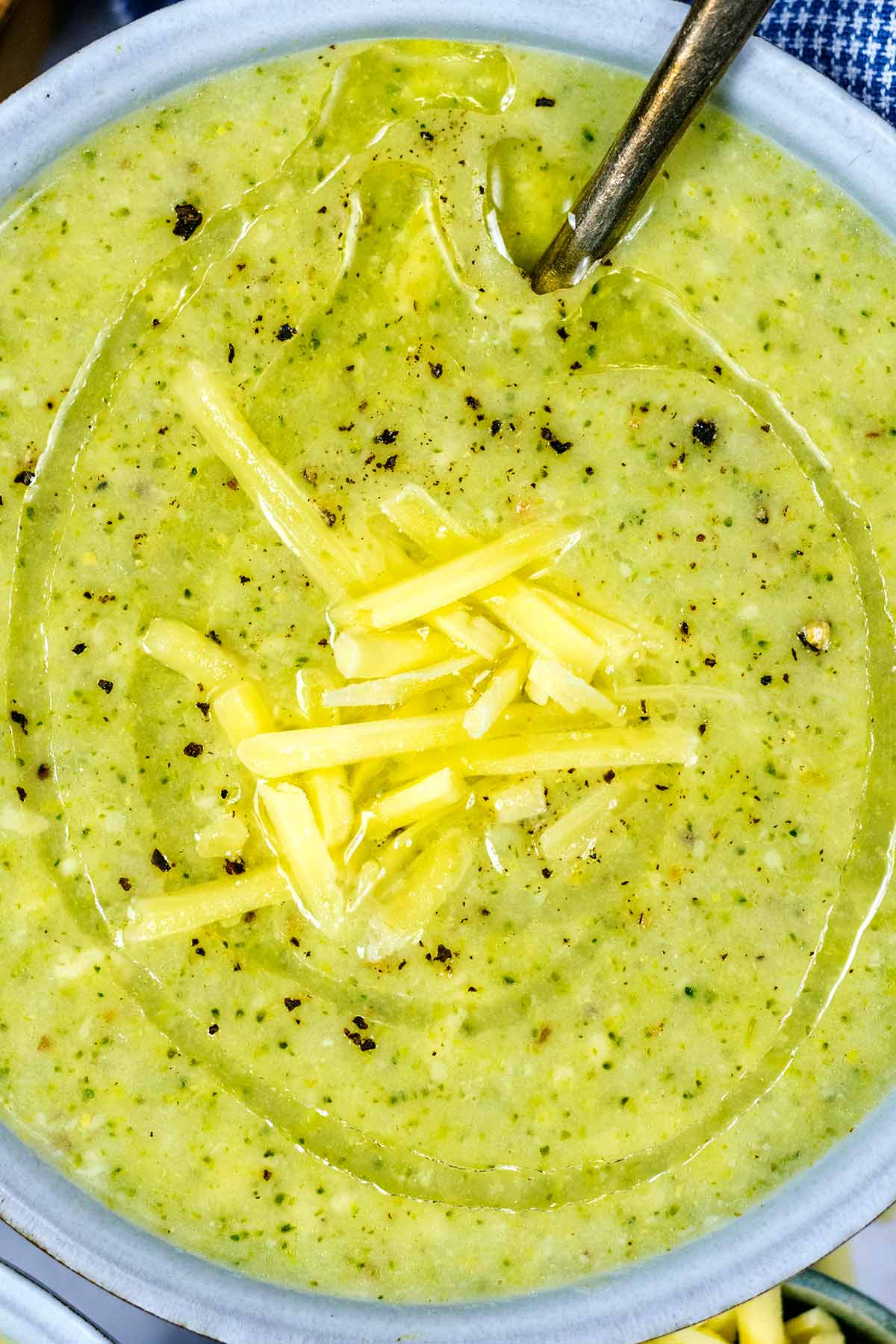 Grated cheese and a drizzle of oil on top of a bowl of soup.