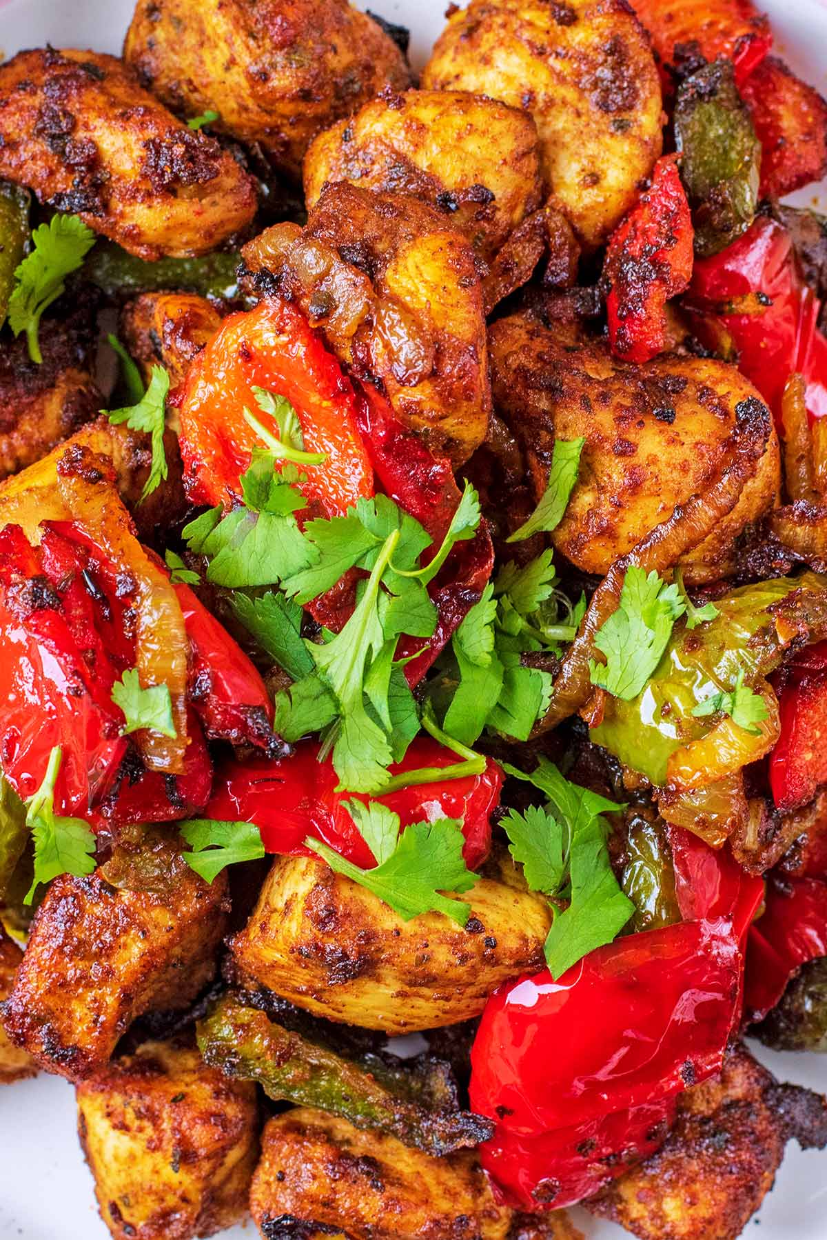 Chicken tikka and chopped vegetables covered in coriander.