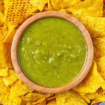 A bowl of Jalapeno Sauce surrounded by tortilla chips.