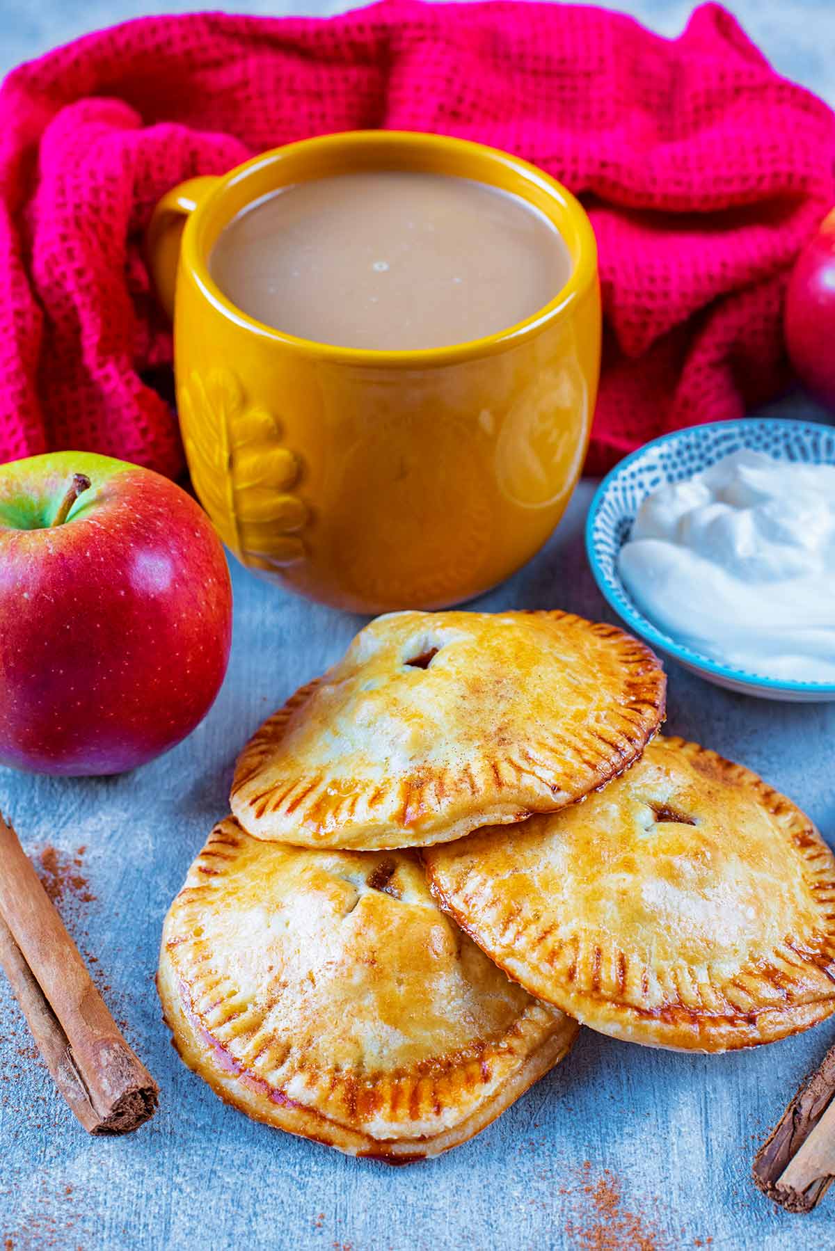 Apple Hand Pies next to a cup of coffee and an apple.