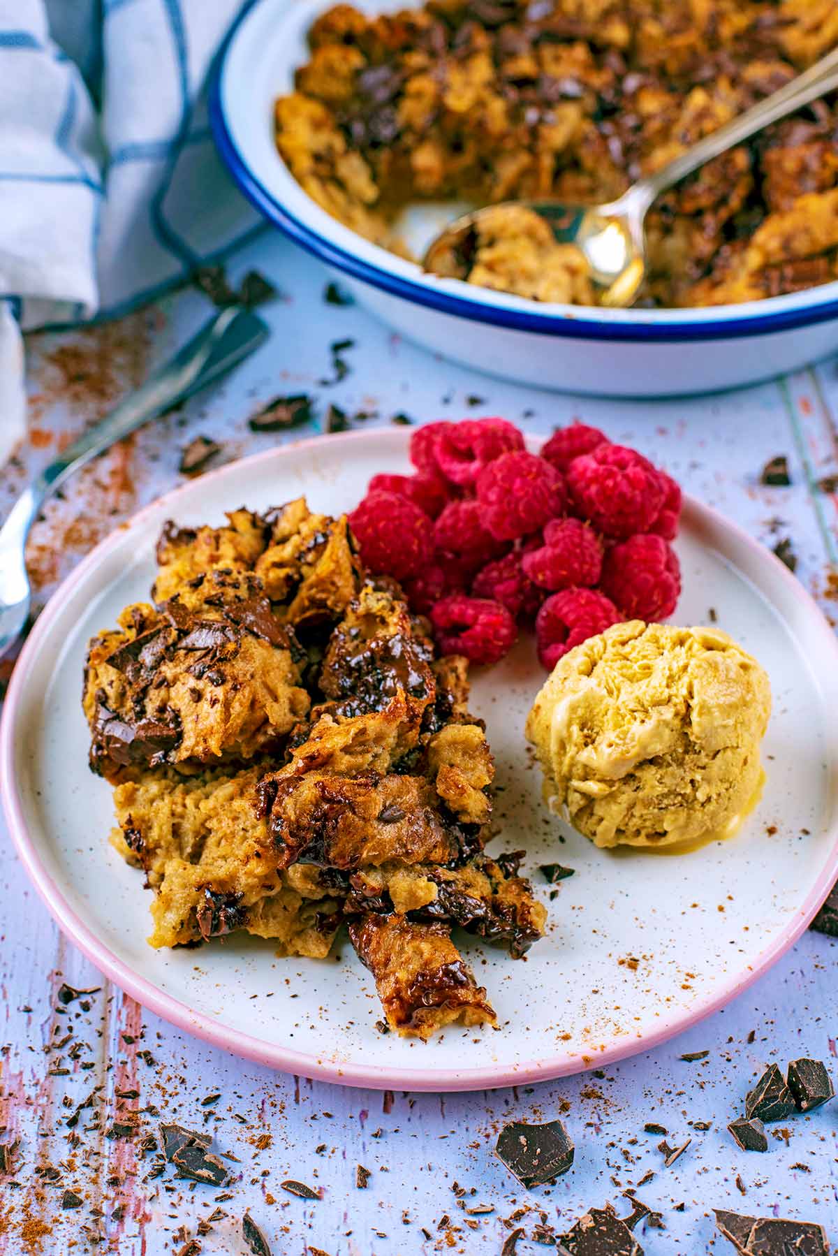 Chocolate Bread Pudding on a plate in front of a dish of more bread pudding.