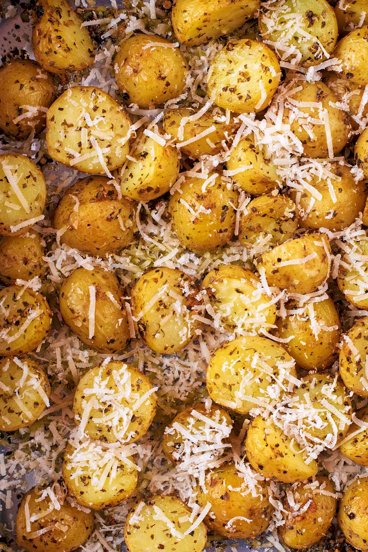 Roasted new potatoes covered in herbs and grated cheese.
