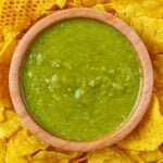 A bowl of Jalapeño Sauce surrounded by tortilla chips.