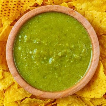 A bowl of Jalapeño Sauce surrounded by tortilla chips.