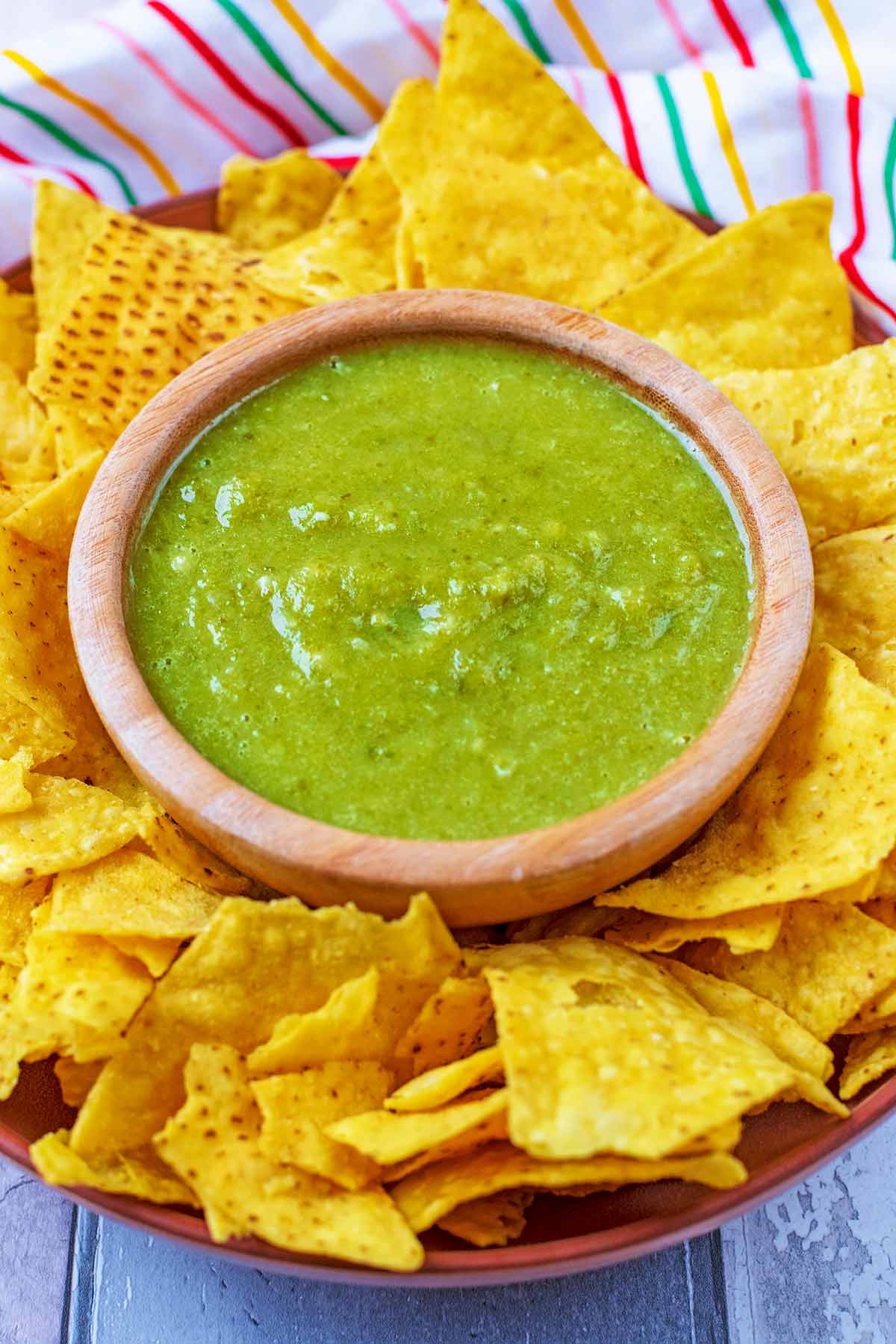 A plate of tortilla chips with a bowl of Jalape&ntilde;o Sauce.