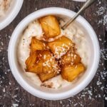 Coconut rice pudding in a bowl with pineapple on top.