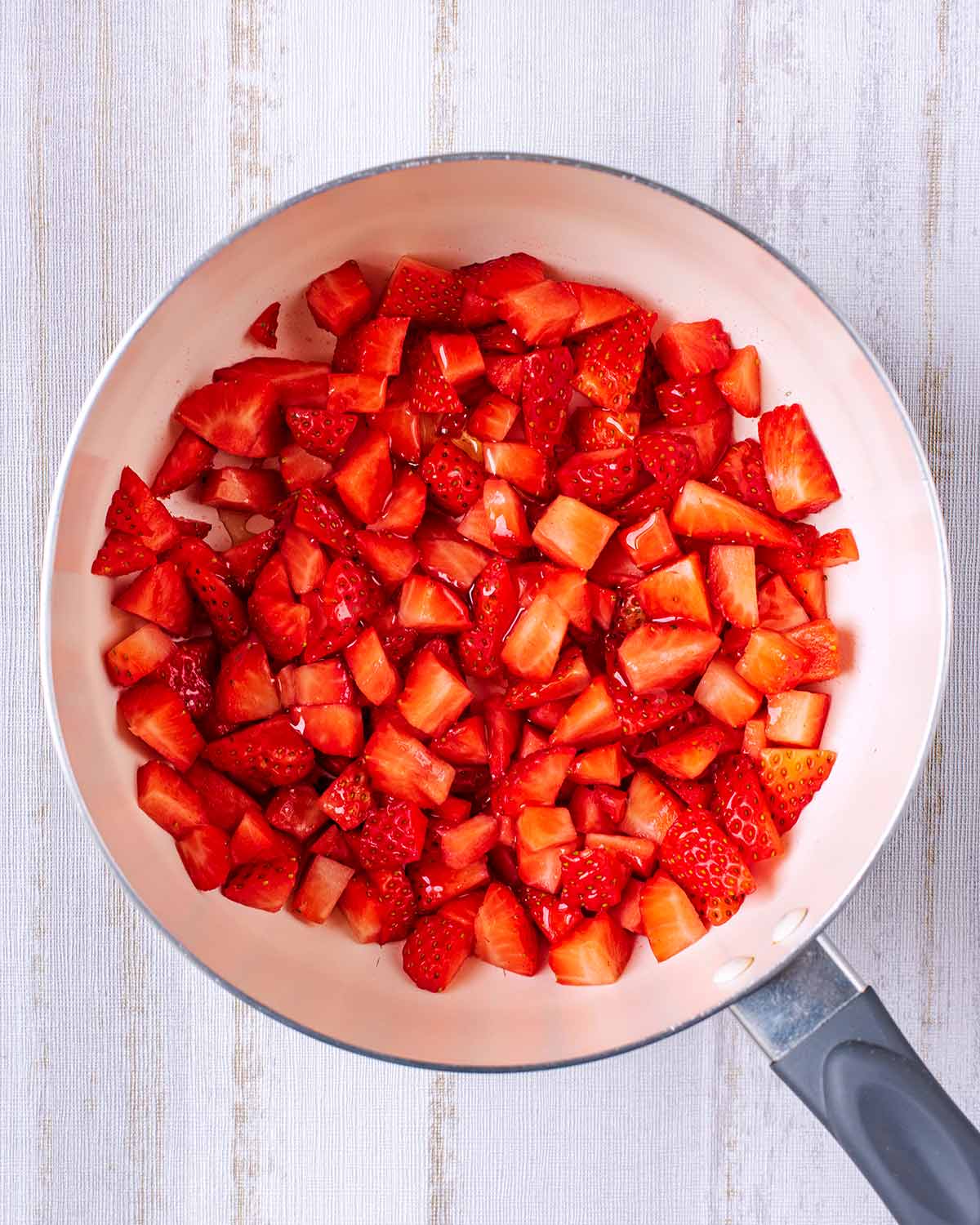 Chopped strawberries in a saucepan.