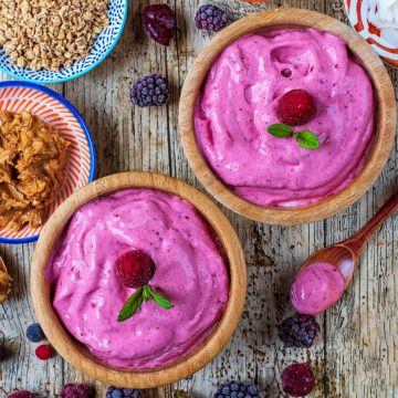 5 Minute Healthy Frozen Yogurt in two wooden bowls topped with raspberries and mint leaves