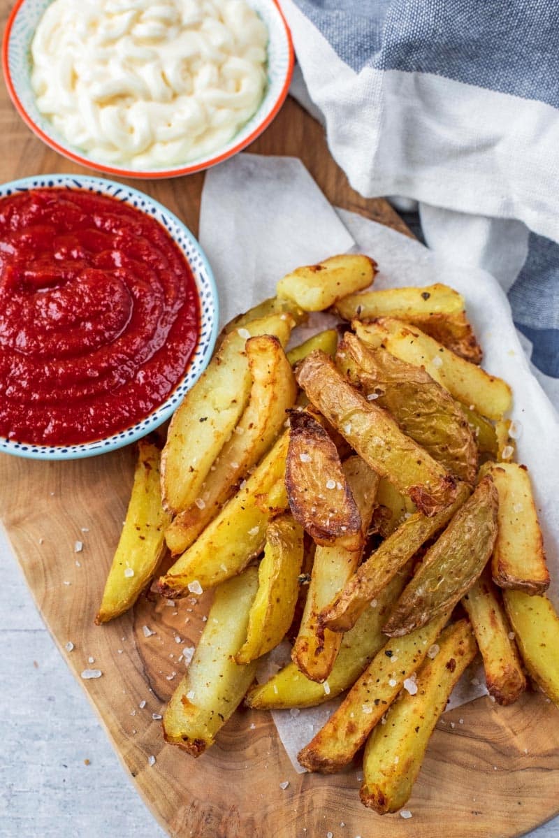 The best Air Fryer Chips next to two bowls of sauce.