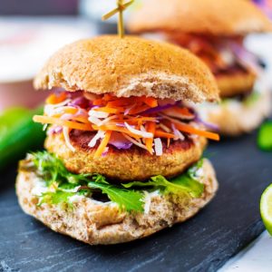 A salmon burger in a bun with lettuce and coleslaw