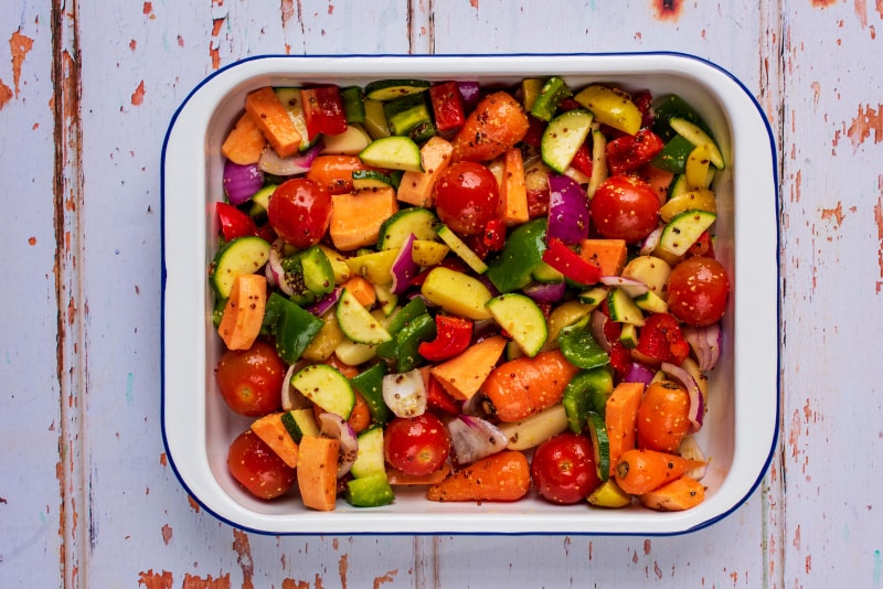 A baking dish containing chopped vegetables.