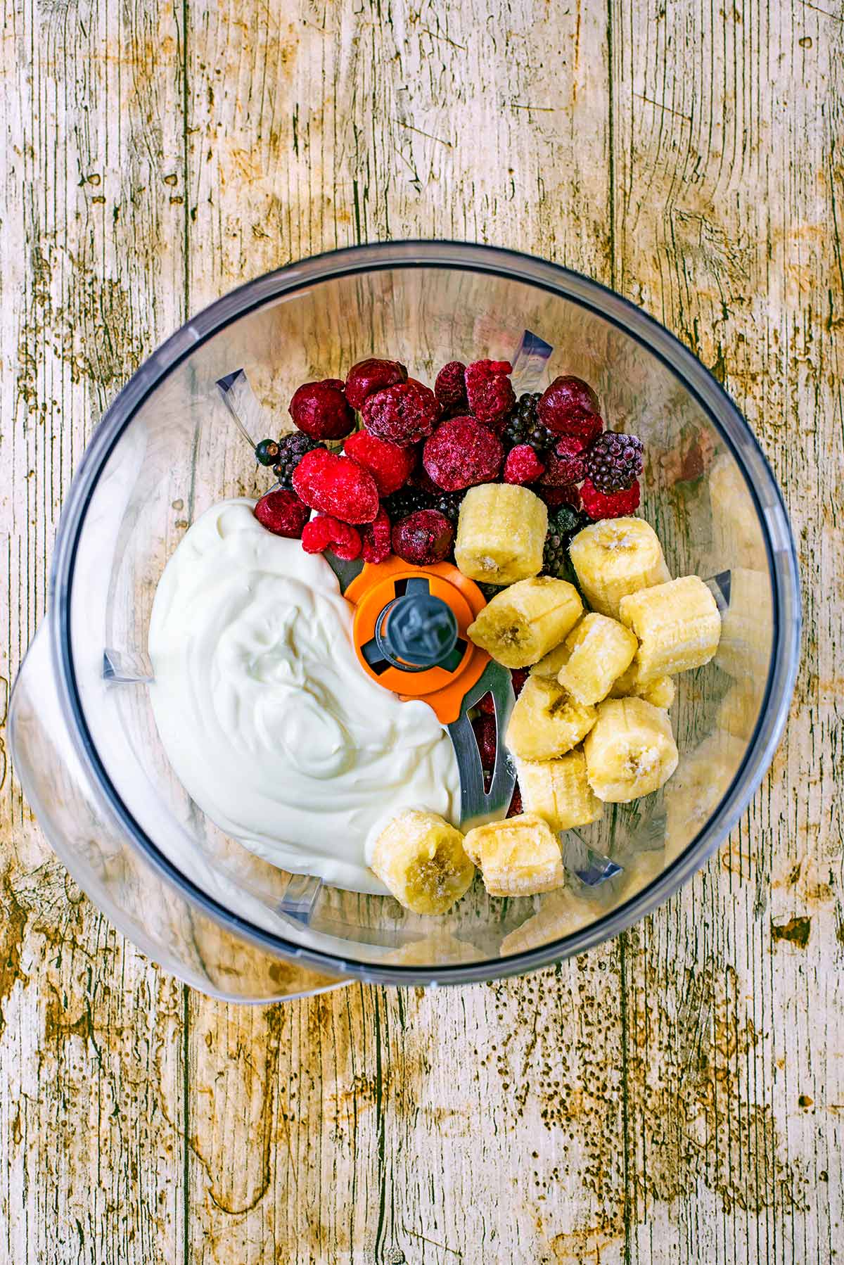 Yogurt, berries and banana chunks in a food processor.