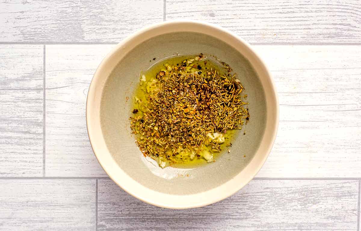 A herb and oil dressing in a small bowl.