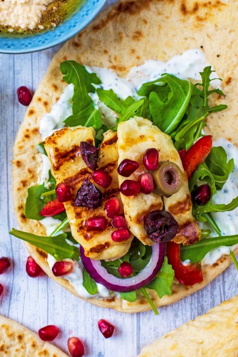 Grilled Halloumi on a bed of lettuce and peppers all on a flatbread.